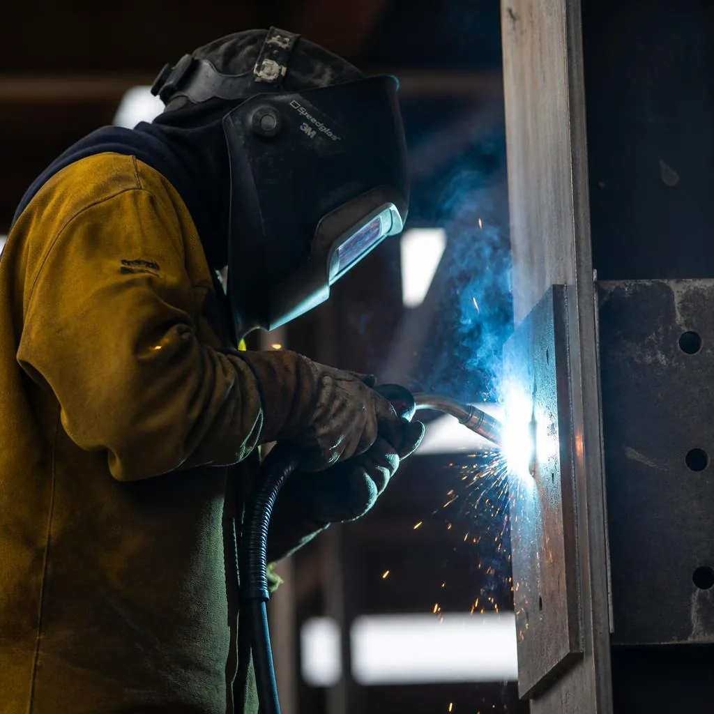 Welder reinforcing a steel beam on site